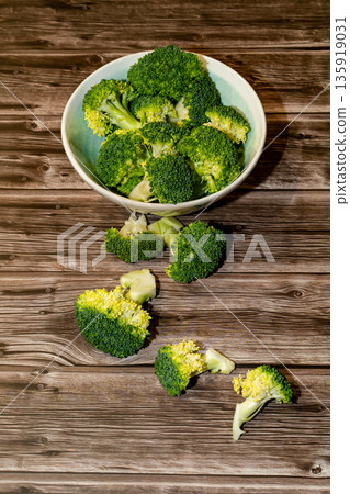 Large round dish with broccoli on a wooden table.  135919031