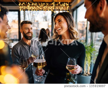 Friends celebrate together with drinks in a bright bar during the evening hours of a weekend gathering 135919897