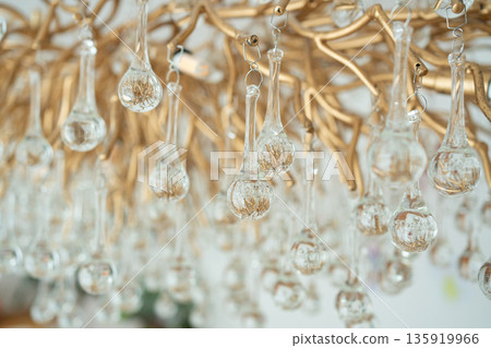 Abstract crystal chandelier background with soft bokeh. Luxury interior decor texture for design, branding and visual content. 135919966