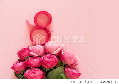 A delicate and creative flat lay celebrating 8 March, International Womens Day. soft pink roses and a ribbon arranged in the shape of 8 on a pastel pink background A delicate and creative flat lay celebrating 8 March, International Womens Day. soft pink roses and a ribbon arranged in the shape of 8 on a pastel pink background 135920115