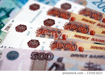 Russian ruble money bills banknotes lies in big pile on table close up. Concept of finances and business in Russian Federation Russian ruble money bills banknotes lies in big pile on table close up. Concept of finances and business in Russian Federation 135921625
