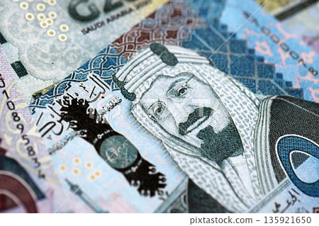Saudi Arabia riyal money bills banknotes lies in big pile on table close up. Concept of finances and business in Saudi Arabia 135921650