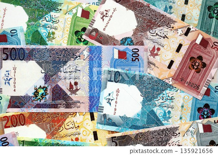 Qatari riyal money bills banknotes lies in big pile on table close up. Concept of finances and business in Qatar 135921656