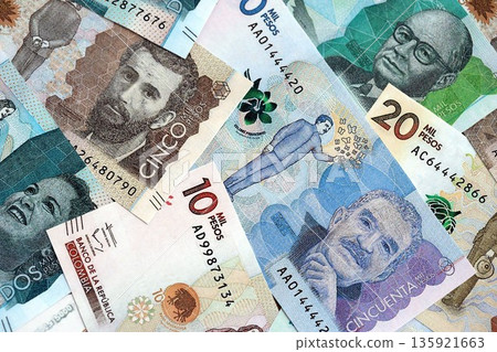 Colombian pesos money bills banknotes lies in big pile on table close up. Concept of finances and business in Colombia Colombian pesos money bills banknotes lies in big pile on table close up. Concept of finances and business in Colombia 135921663