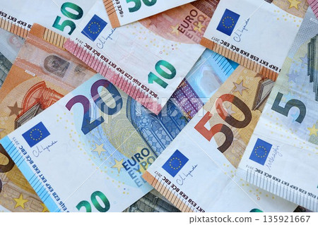 Euro money bills banknotes in big amount on table close up. Huge quantity of European Union currency cash on smooth surface. Business and rich life concept Euro money bills banknotes in big amount on table close up. Huge quantity of European Union currency cash on smooth surface. Business and rich life concept 135921667