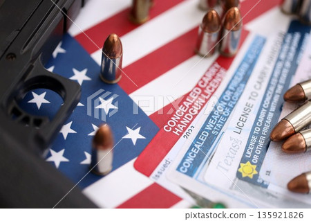USA firearms license and handgun with bullets on US flag close up. Gun permit and Constitution second amendment concept 135921826