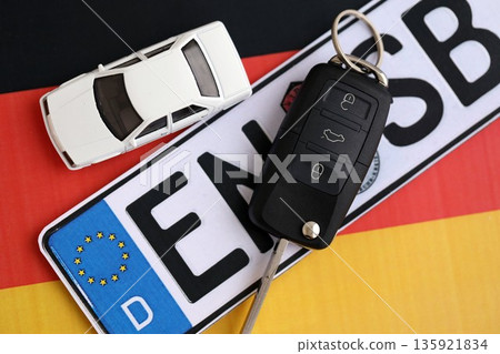 Germany Deutschland car license plate and key on german flag close up. Driving permit and registration concept Germany Deutschland car license plate and key on german flag close up. Driving permit and registration concept 135921834