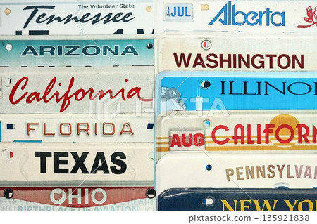 Old US car license plates with various state names. Concept of driving in United States. Reaching a car registration 135921838