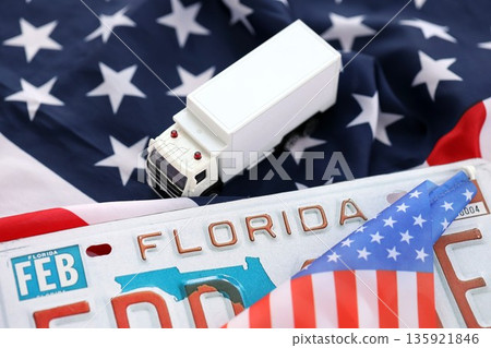 Toy truck and USA state of Florida license plate on US flag. Concept of driving in Florida. Reaching a driving permit 135921846