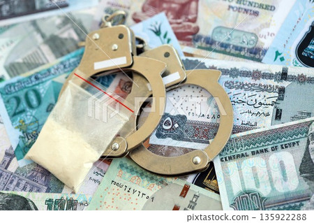 Egyptian pound currency money bills and cocaine pack with handcuffs close up. The concept of drug crimes 135922288