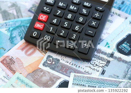 Egyptian pound currency money bills and calculator close up. The concept of taxation and money count Egyptian pound currency money bills and calculator close up. The concept of taxation and money count 135922292