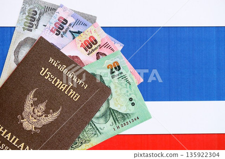 Thai baht currency money bills and passport lies on flag close up. The concept of travel and vacation 135922304
