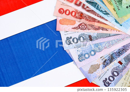 Thai baht currency money bills lies on flag close up. The concept of business and investment Thai baht currency money bills lies on flag close up. The concept of business and investment 135922305