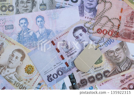 Thai baht currency money bills and military token close up. The concept of army service 135922315