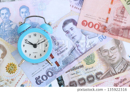 Thai baht currency money bills and alarm clock close up. The concept of time management and income 135922316