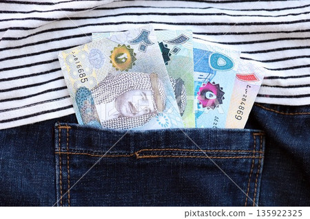 Bahraini dinar money bills in denims pocket close up. The concept of fashion and wealth Bahraini dinar money bills in denims pocket close up. The concept of fashion and wealth 135922325