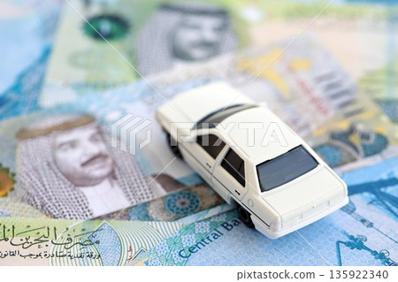 Bahraini dinar currency money bills and toy car close up. The concept of car ownership Bahraini dinar currency money bills and toy car close up. The concept of car ownership 135922340