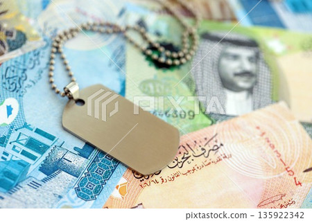 Bahraini dinar currency money bills and military token close up. The concept of army service Bahraini dinar currency money bills and military token close up. The concept of army service 135922342