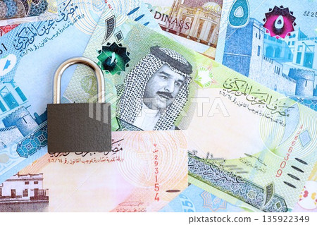 Bahraini dinar currency money bills and padlock close up. The concept of sanctions and financial safety Bahraini dinar currency money bills and padlock close up. The concept of sanctions and financial safety 135922349