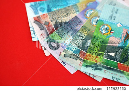 Kuwaiti dinar money bills in big amount on red close up. Finance and banking concept Kuwaiti dinar money bills in big amount on red close up. Finance and banking concept 135922360