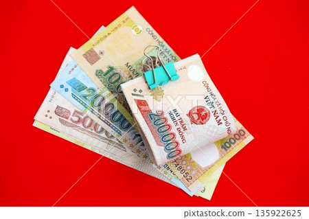Vietnamese dong money bills in big amount close up on red. Finance and banking concept 135922625