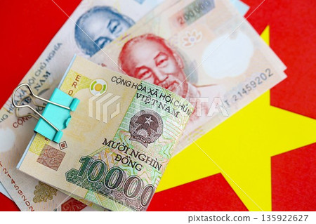 Vietnamese dong currency money bills lies on flag close up. The concept of business and investment 135922627