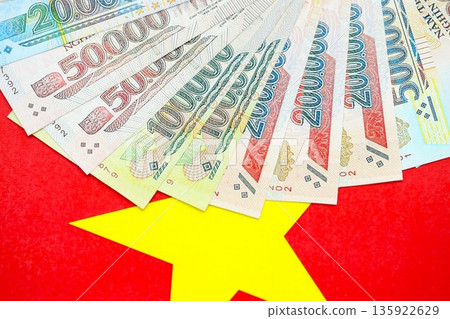 Vietnamese dong currency money bills lies on flag close up. The concept of business and investment 135922629