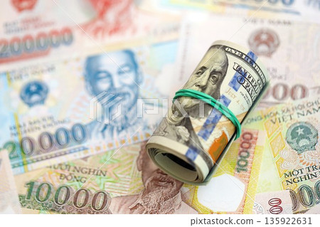 Vietnamese dong currency money bills and bunch of us dollar banknotes close up. The concept of economics and currency exchange 135922631
