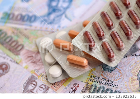 Vietnamese dong currency money bills and medicine pills close up. The concept of medicine and pharmacy 135922633