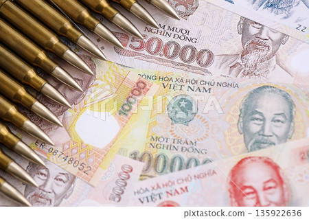 Vietnamese dong currency money bills and rifle bullets close up. The concept of warfare and gun selling 135922636