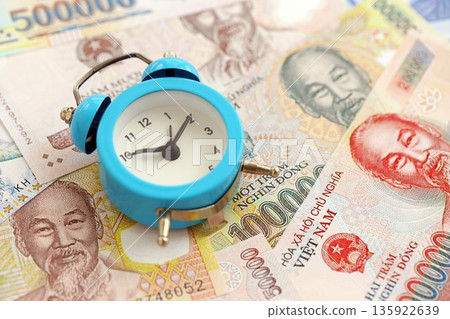 Vietnamese dong currency money bills and alarm clock close up. The concept of time management and income 135922639