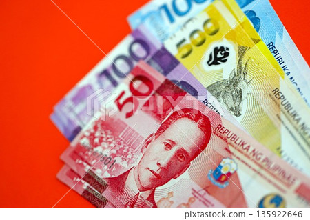 Philippines peso money bills in big amount close up on red. Finance and banking concept Philippines peso money bills in big amount close up on red. Finance and banking concept 135922646