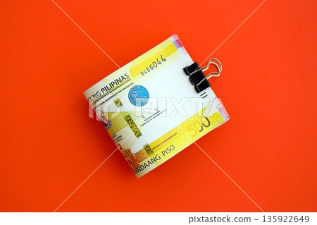 Philippines peso money bills in big amount close up on red. Finance and banking concept Philippines peso money bills in big amount close up on red. Finance and banking concept 135922649