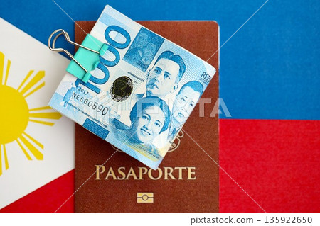 Philippines peso currency money bills and passport lies on flag close up. The concept of travel and vacation 135922650