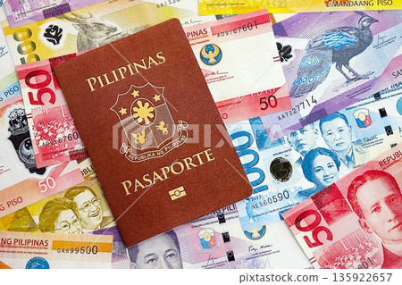 Philippines peso currency money bills and passport close up. The concept of travel and vacation Philippines peso currency money bills and passport close up. The concept of travel and vacation 135922657