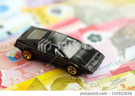 Philippines peso currency money bills and toy car close up. The concept of car ownership Philippines peso currency money bills and toy car close up. The concept of car ownership 135922659