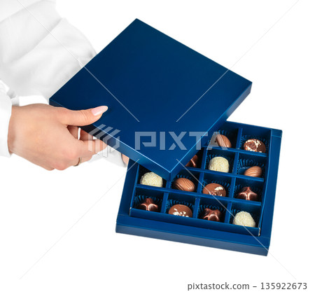 Hands opening blue luxury chocolate gift box isolated on white Hands opening blue luxury chocolate gift box isolated on white 135922673