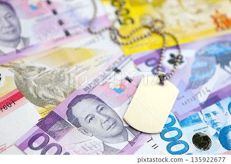 Philippines peso currency money bills and military token close up. The concept of army service Philippines peso currency money bills and military token close up. The concept of army service 135922677