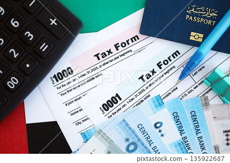 United Arab Emirates dirham money bills and calculator with tax form on flag close up. Taxation and accounting concept 135922687