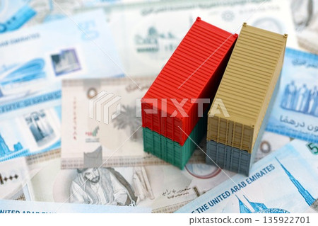 United Arab Emirates dirham currency money bills and toy cargo containers close up. The concept of shipping and logistics United Arab Emirates dirham currency money bills and toy cargo containers close up. The concept of shipping and logistics 135922701
