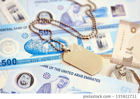 United Arab Emirates dirham currency money bills and military token close up. The concept of army service United Arab Emirates dirham currency money bills and military token close up. The concept of army service 135922711
