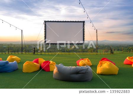 open air cinema with colorful bean bag. empty white screen, free space for text or montage. 135922883