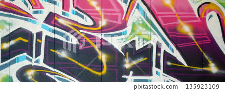 Colorful background of graffiti painting artwork with bright aerosol outlines on wall. Old school street art piece made with aerosol spray paint cans. Contemporary youth culture backdrop 135923109