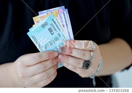Woman hand with indian rupees bills close up. Concept of financial operations in cash in India 135923268