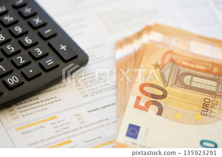 Filling italian tax form process with pen, calculator and euro money bills close up. Tax paying period and deadline Filling italian tax form process with pen, calculator and euro money bills close up. Tax paying period and deadline 135923291