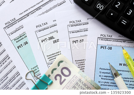 Declaration of the amount of earned income or incurred loss, PIT-36, PIT-36L, PIT-37 and PIT-38 tax forms on accountant table with pen and polish zloty money bills close up 135923300