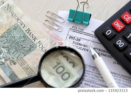 Declaration of amount of income obtained, amount of deductions made and lump sum due from recorded income, PIT-28 form on accountant table with pen and polish zloty money bills close up 135923315