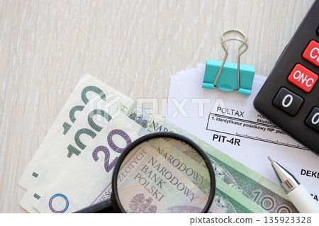Annual declaration of income tax advances, PIT-4R form on accountant table with pen and polish zloty money bills close up Annual declaration of income tax advances, PIT-4R form on accountant table with pen and polish zloty money bills close up 135923328