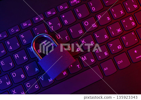 Computer security concept with a closed padlock on the keyboard. Padlock on top of a laptop keyboard. Selective focus Toned image Computer security concept with a closed padlock on the keyboard. Padlock on top of a laptop keyboard. Selective focus Toned image 135923343