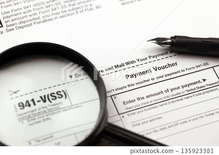 IRS Form 941-V Payment Voucher blank on A4 tablet lies on office table with pen and magnifying glass close up 135923381